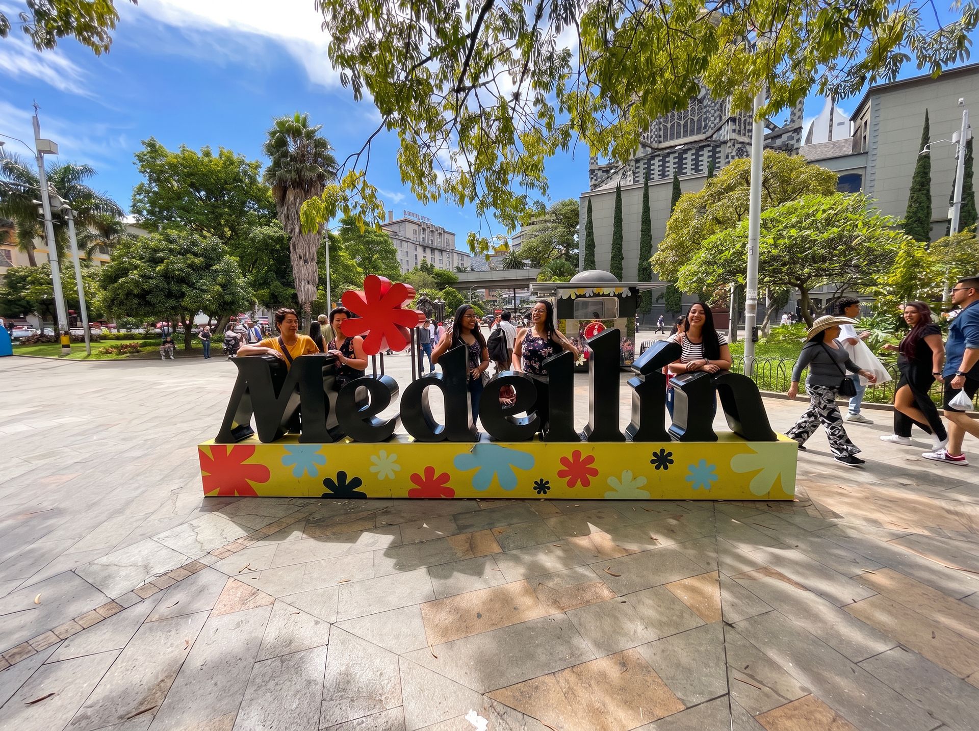 Letrero de Medellín en una plaza soleada de la ciudad, símbolo de bienvenida para viajeros